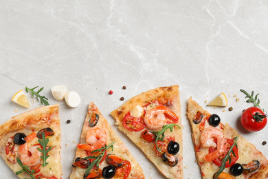Tasty pizza with seafood and ingredients on light grey marble table, flat lay. Space for text