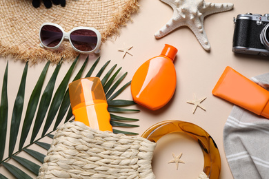 Flat lay composition with sun protection products and beach accessories on beige background