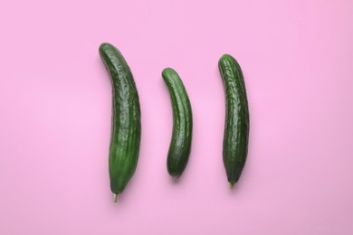 Fresh ripe cucumbers on pink background, flat lay