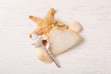 Scented sachet, starfish and sea shells on white wooden table, flat lay