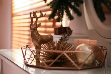 Composition with decorative reindeer and Christmas tree near window on table, closeup