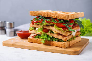 Photo of Yummy sandwich with tomato sauce on white wooden table