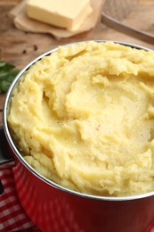 Photo of Red pot with tasty mashed potatoes on table, closeup