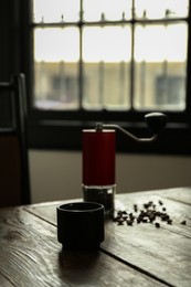 Photo of Aromatic coffee and beans on wooden table in cafe, space for text