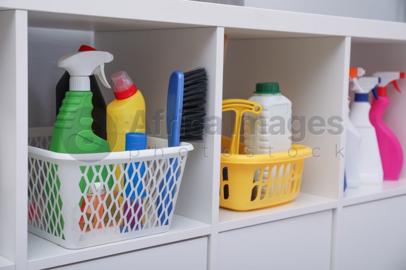 White shelving unit with set of detergents and cleaning tools