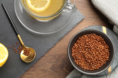Buckwheat tea and granules on wooden table, flat lay