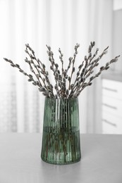 Beautiful bouquet of pussy willow branches on table indoors