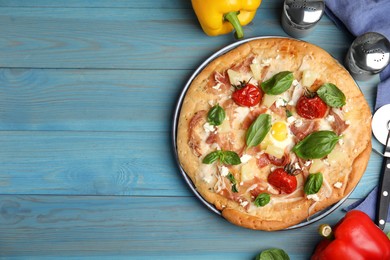 Delicious homemade pita pizza and ingredients on light blue wooden table, flat lay. Space for text