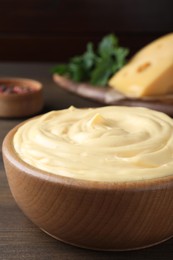 Tasty cheese sauce in bowl on wooden table, closeup