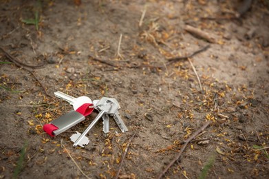 Keys on ground outdoors, space for text. Lost and found