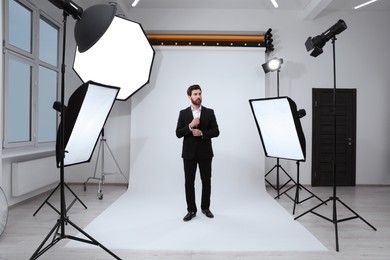 Photo of Handsome model posing in modern studio. Professional photo session