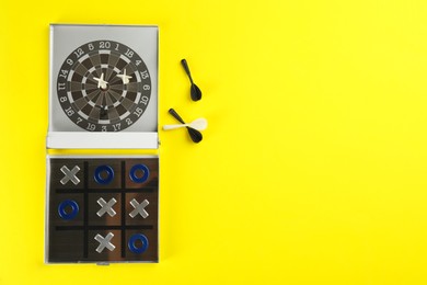 Board games on yellow background, flat lay. Space for text