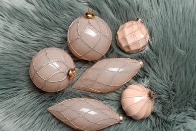 Collection of beautiful Christmas tree baubles on light grey faux fur, flat lay