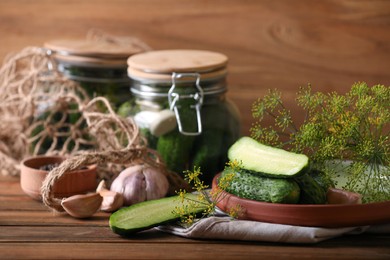 Fresh cucumbers and other ingredients prepared for canning on wooden table