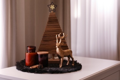 Composition with decorative Christmas tree and reindeer near window, space for text