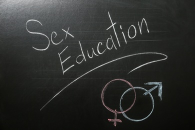 Gender symbols and phrase "SEX EDUCATION" written on black chalkboard