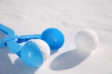 Snowballs and light blue plastic tool outdoors on winter day, closeup