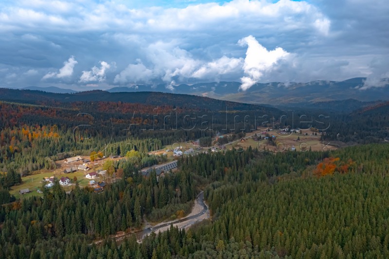 Aerial view of mountain forest and village on autumn day