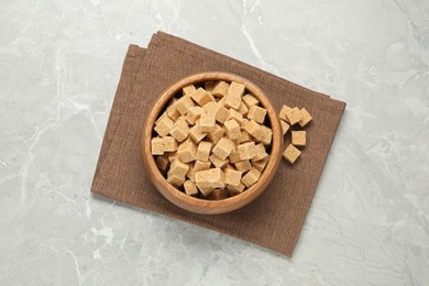Brown sugar cubes on light grey marble table, flat lay