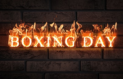 Flaming text Boxing Day against brick wall