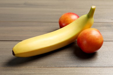 Banana and nectarines symbolizing male genitals on wooden table. Potency concept