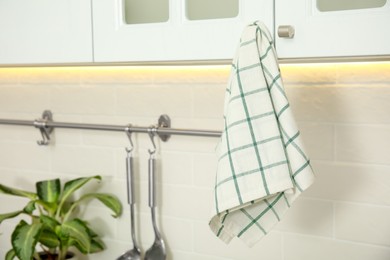 Photo of Clean towel hanging on cabinet handle in kitchen