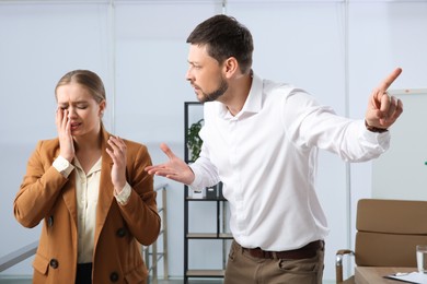 Man scolding woman in office. Toxic work environment