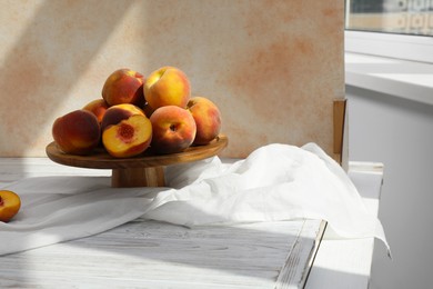 Stand with juicy peaches and double-sided backdrop in photo studio