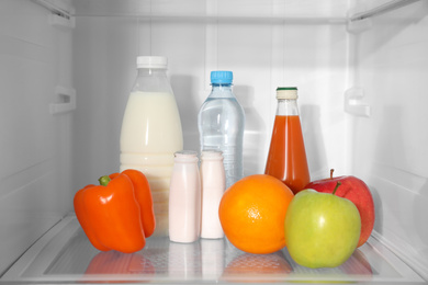 Different products on shelf inside modern refrigerator