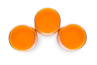 Three glasses of fresh carrot juice on white background, top view