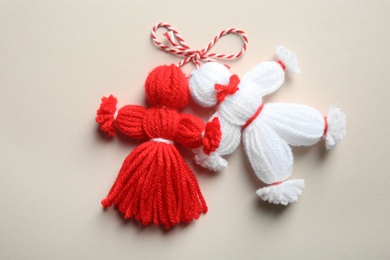 Photo of Traditional martisor shaped as man and woman on light background, top view. Beginning of spring celebration