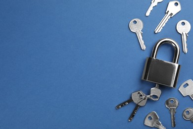 Modern padlock with keys on blue background, flat lay. Space for text