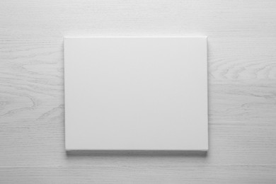 Blank canvas on white wooden background, space for text