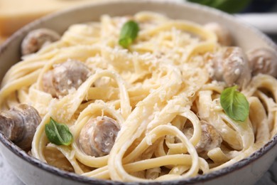 Photo of Delicious pasta with mushrooms and cheese in bowl, closeup