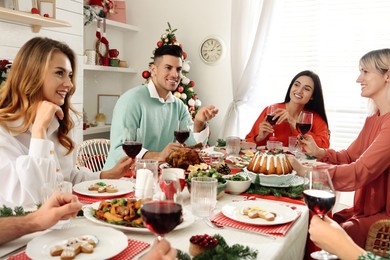 Happy family with their friends enjoying festive dinner at home. Christmas Eve celebration