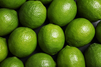 Fresh ripe green limes as background, top view