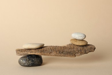 Tree branch with stones on beige background. Harmony and balance concept