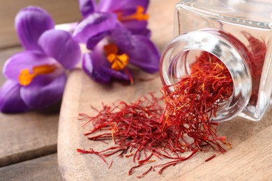 Dried saffron and crocus flowers on wooden table, closeup. Space for text