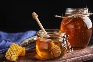 Photo of Jar of sweet honey on wooden board