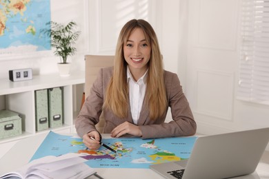 Happy manager working at desk in travel agency