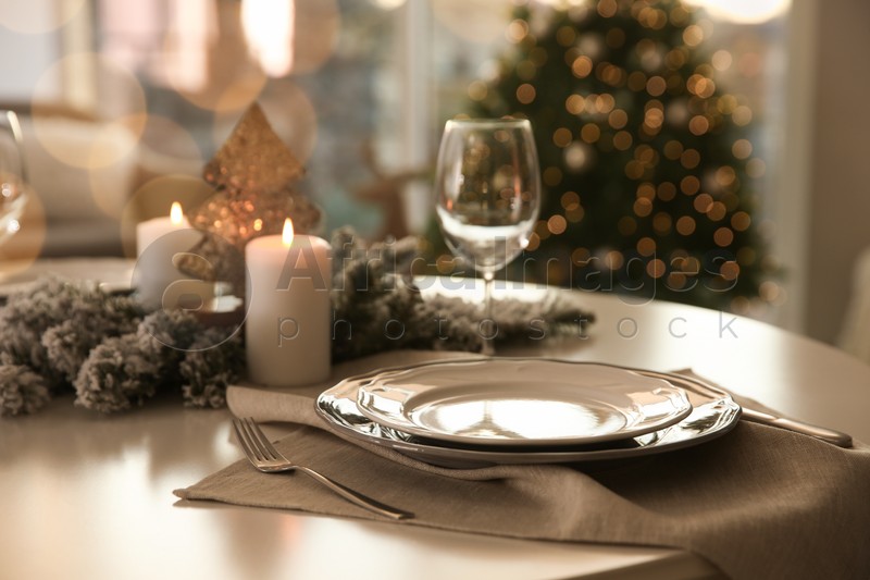 Festive table setting in room decorated for Christmas