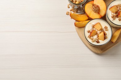 Delicious yogurt with fresh peach and granola on white wooden table, top view. Space for text