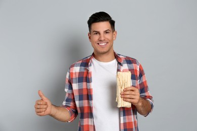 Photo of Man with delicious shawarma on grey background