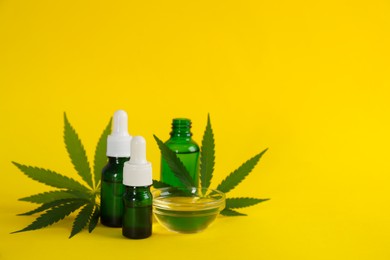 Hemp leaves, CBD oil and THC tincture on yellow background. Space for text