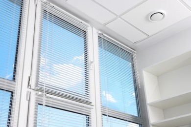 Large window with horizontal blinds indoors, low angle view