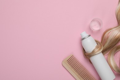 Lock of healthy blond hair, comb and cosmetic product on pink background, flat lay. Space for text