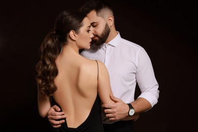 Handsome bearded man with sexy lady on dark background