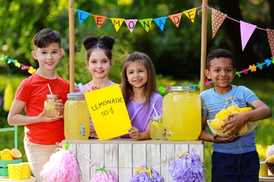 Cute little children at lemonade stand in park. Summer refreshing natural drink