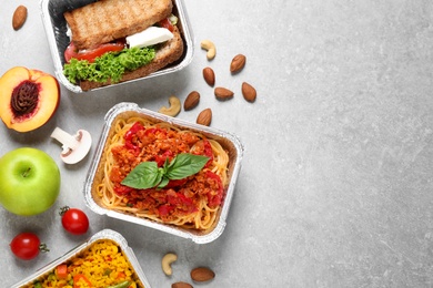 Lunchboxes on light grey table, flat lay. Healthy food delivery