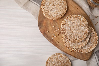 Stack of fresh crunchy rice cakes on white wooden table, flat lay. Space for text